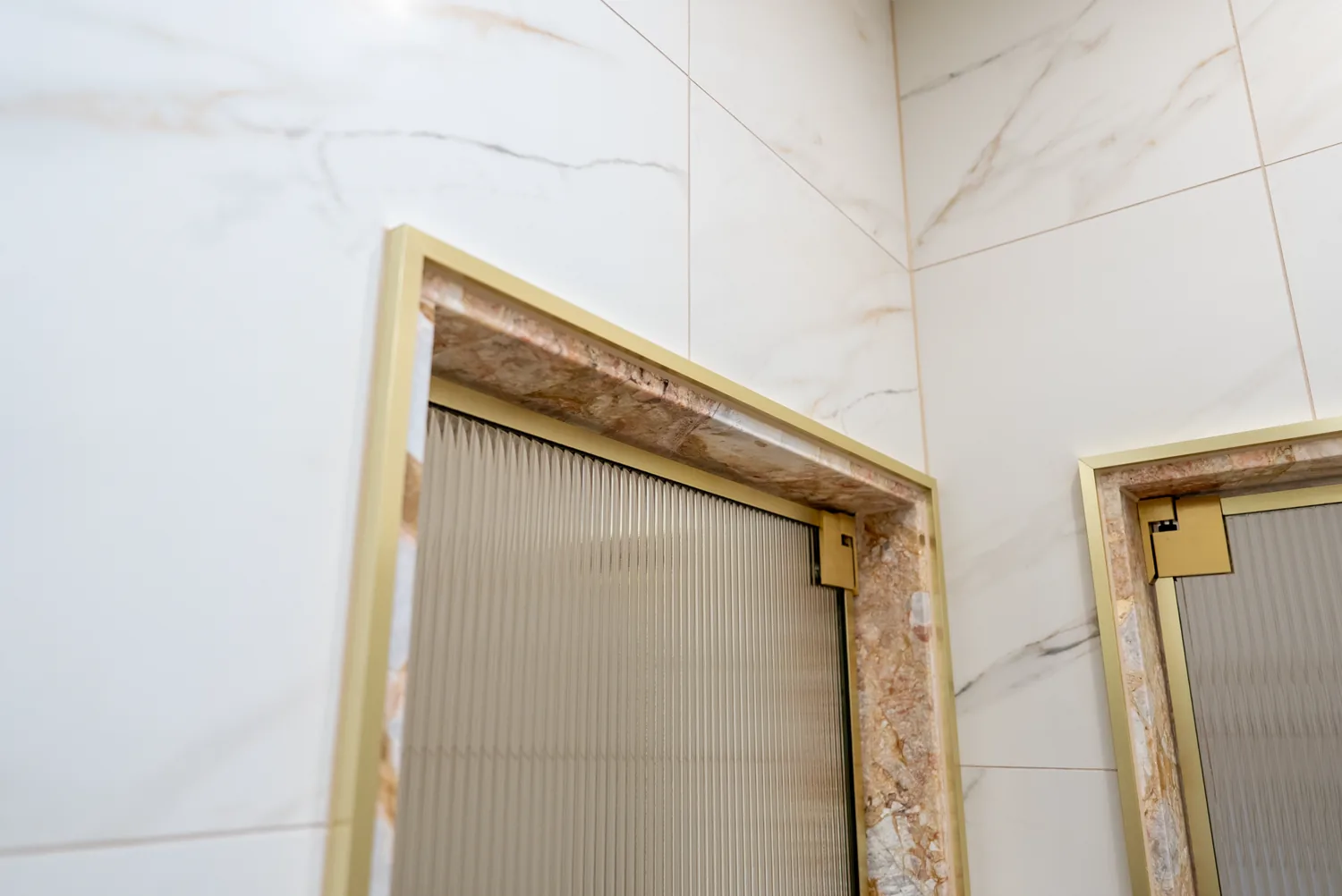 Fluted glass shower screen framed in brushed brass