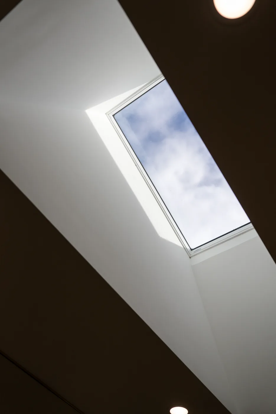 Skylight bringing natural light into a marble bathroom