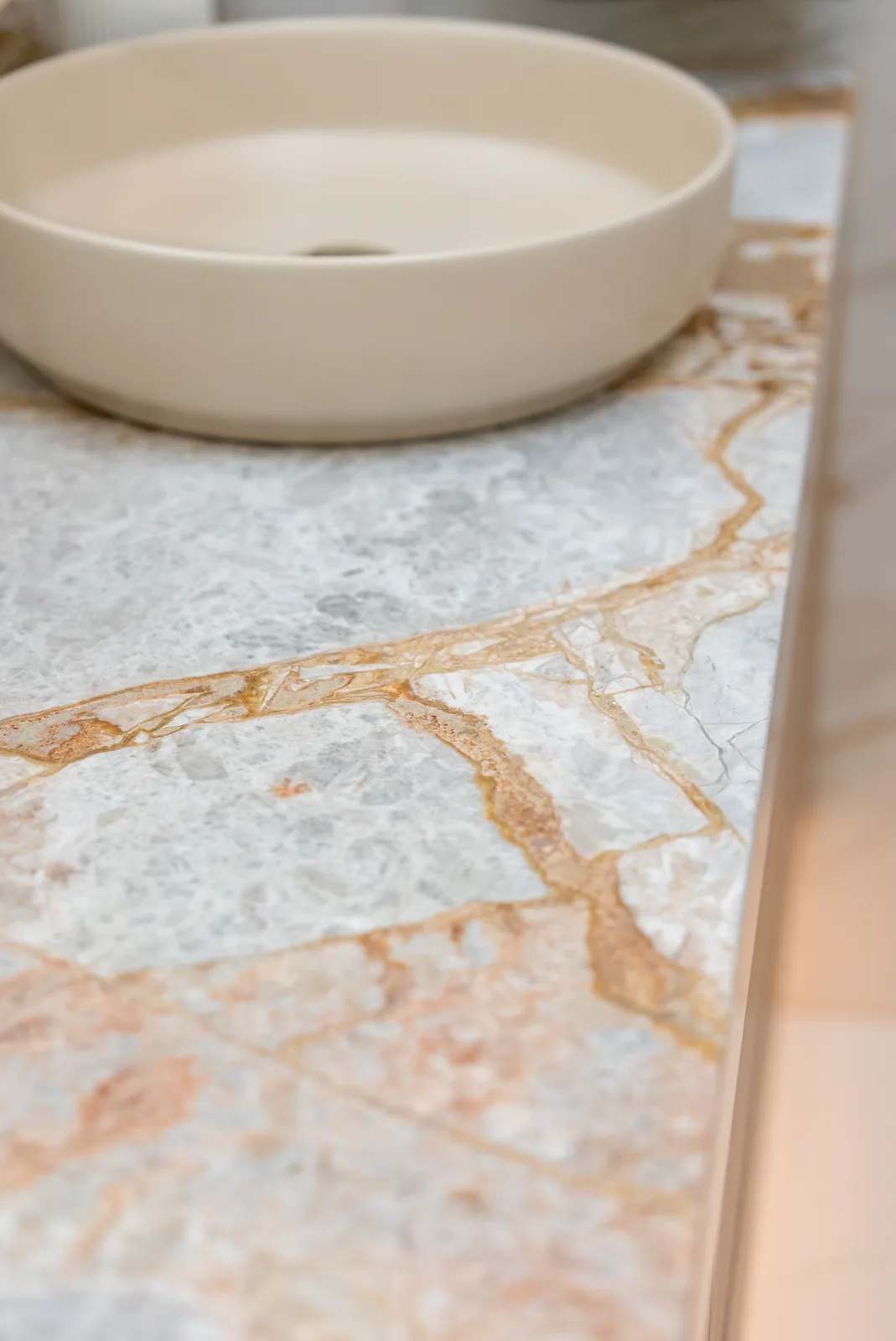 Stone vessel basin set on a gold-veined marble benchtop